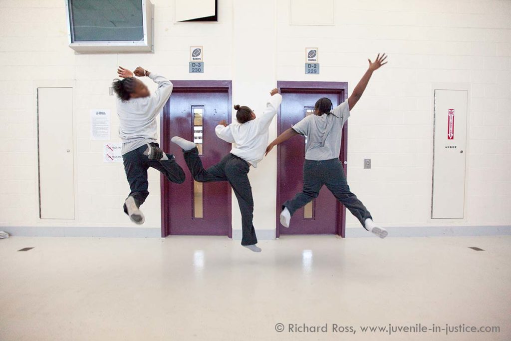 The young women dressed jump in the air in a detention center.